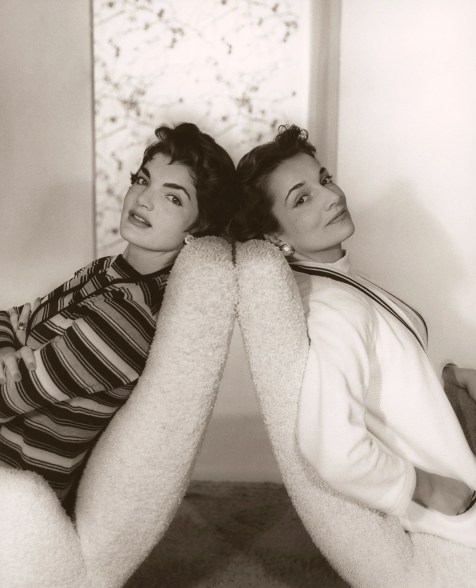 Mrs. John F. Kennedy and her sister Mrs. Michael T. Canfield, formerly Jacqueline and Lee Bouvier, seated in chairs that are back to back. Jacqueline Kennedy wears a striped sweater set and Lee Canfield (later, Radziwill) wears a white sweater set.