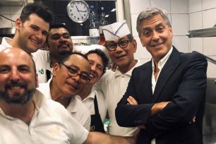 George Clooney poses with kitchen staff at Da Ivo in Venice.