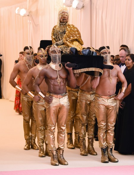 Being carried into the Met Gala like the king of style he is.