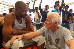 Richard Gere, right, talks with migrants