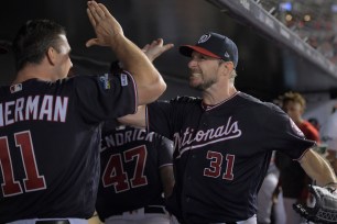 Washington Nationals starting pitcher Max Scherzer (right) high fives Washington Nationals first baseman Ryan Zimmerman