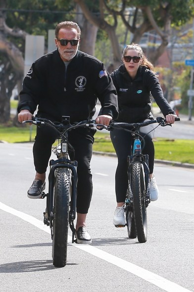 Arnold Schwarzenegger enjoys a bike ride with his daughter, Christina, in Brentwood, Calif.