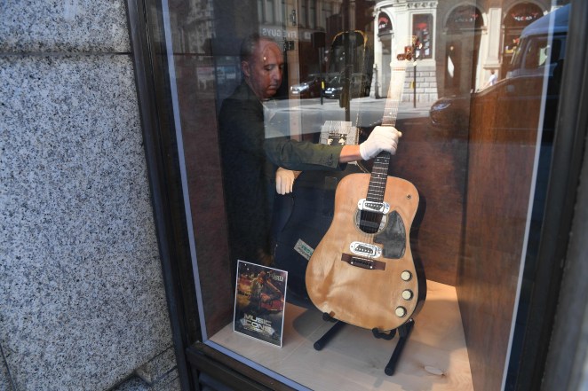 Co-owner of Julien's Auctions, Martin Nolan displays the guitar used by musician Kurt Cobain during Nirvana's famous MTV Unplugged in New York concert in 1993, at the Hard Rock Cafe Piccadilly Circus in central London on May 15, 2020, prior to the auction of the guitar in Beverly Hills in June.