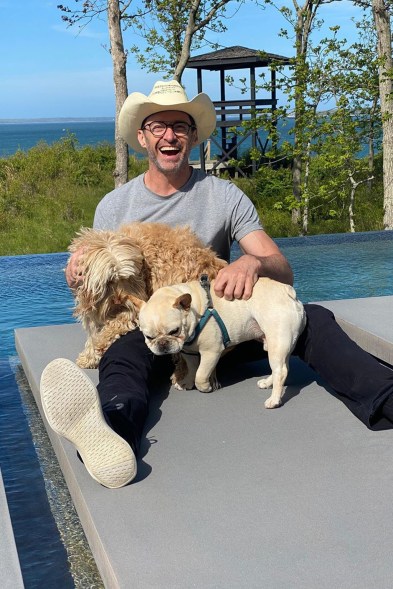 Hugh Jackman tans with his pups Dali and Allegra at his Hamptons home.