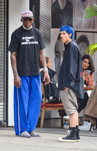 Dennis Rodman's pants match his pal's hair as they smoke outside in New York.