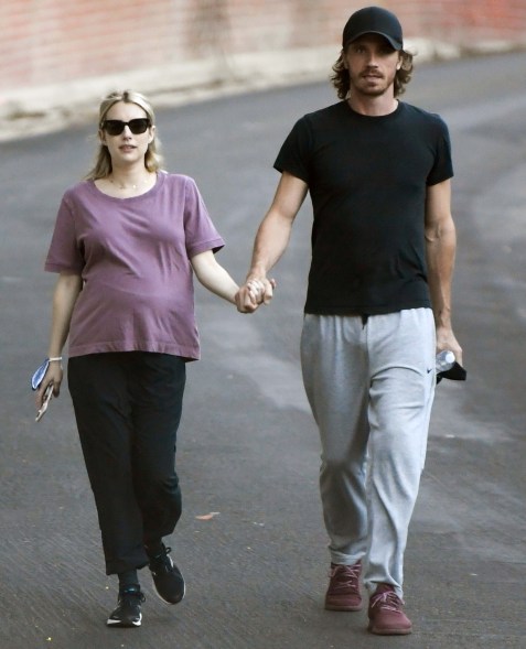 Pregnant Emma Roberts and her boyfriend, Garrett Hedlund, hold hands on a stroll in Los Angeles.