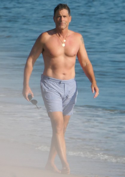 Rob Lowe takes his shirt off for a walk on the beach in Santa Barbara.