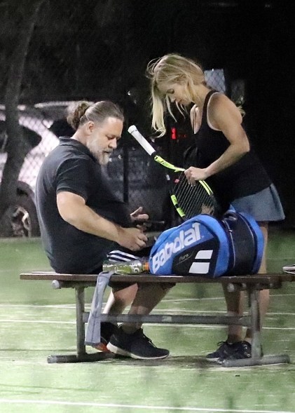 Russell Crowe and pal Britney Theriot take a break from their game of tennis in Sydney.