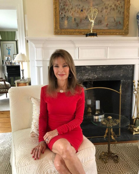 Susan Lucci proudly poses in front of her hard won Emmy award as she shoots a Go Red for Women video from home.