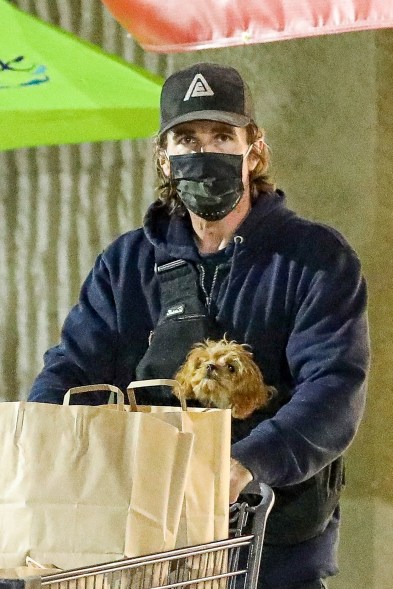 Christian Bale brings his dog with him in a doggy pouch carrier while out grocery shopping in the Pacific Palisades neighborhood.