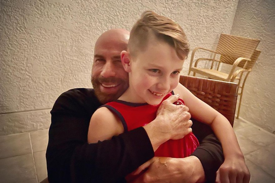 Recently widowed John Travolta embraces his son, Ben, on the boy's 10th birthday.