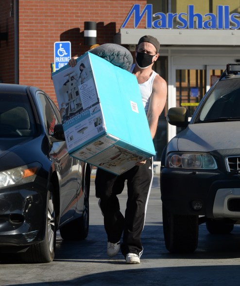 Colin Farrell has his hands full as he carries a 7-level cat tree and a bed for a furry friend.