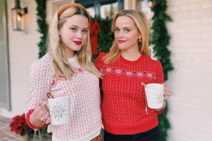 Reese Witherspoon and lookalike daughter Ava Phillippe pose in matching Draper James holiday sweaters.