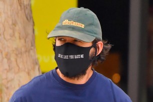Shia LaBeouf wears a mask with "Love Me Like You Hate Me" on it