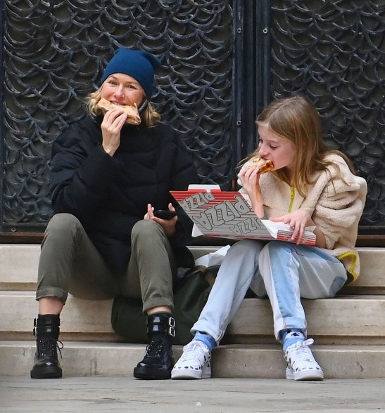 Naomi Watts and child Kai, 11, munch on pizza on a sidewalk in Venice, Italy.