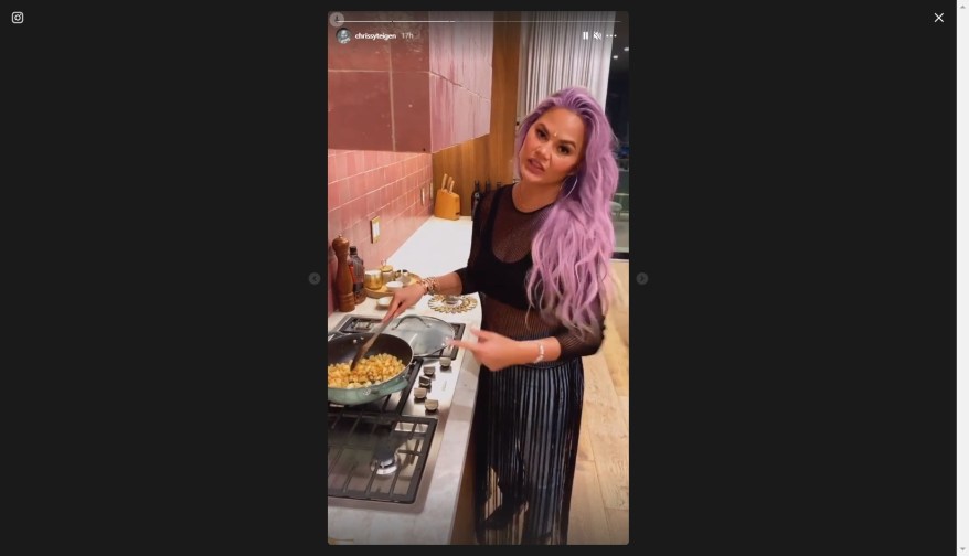 Chrissy Teigen shows off her new violet hair while cooking in LA.