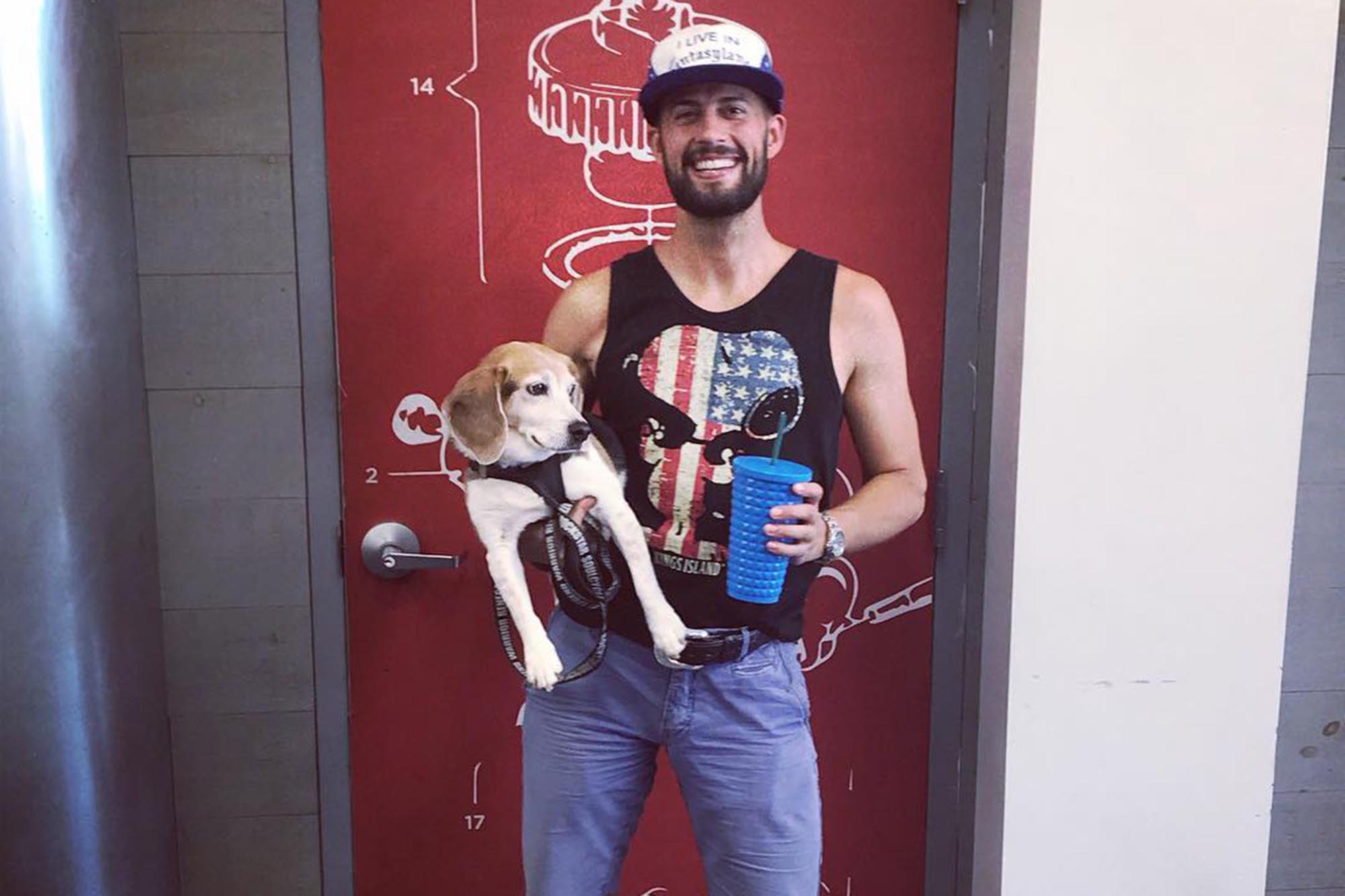 Lady Gaga's dog walker, Ryan Fischer, poses with a pup.