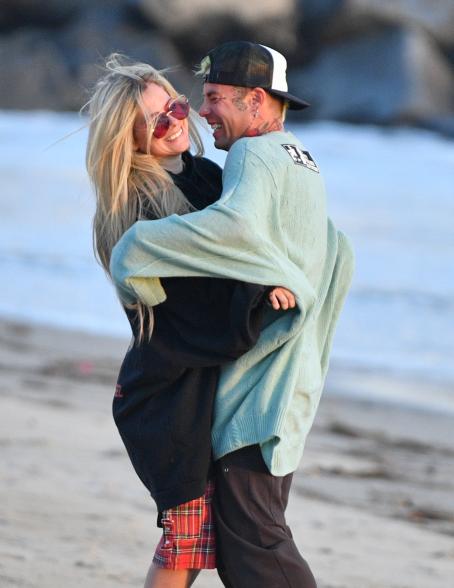 Avril Lavigne and Mod Sun hug and kiss on the beach.