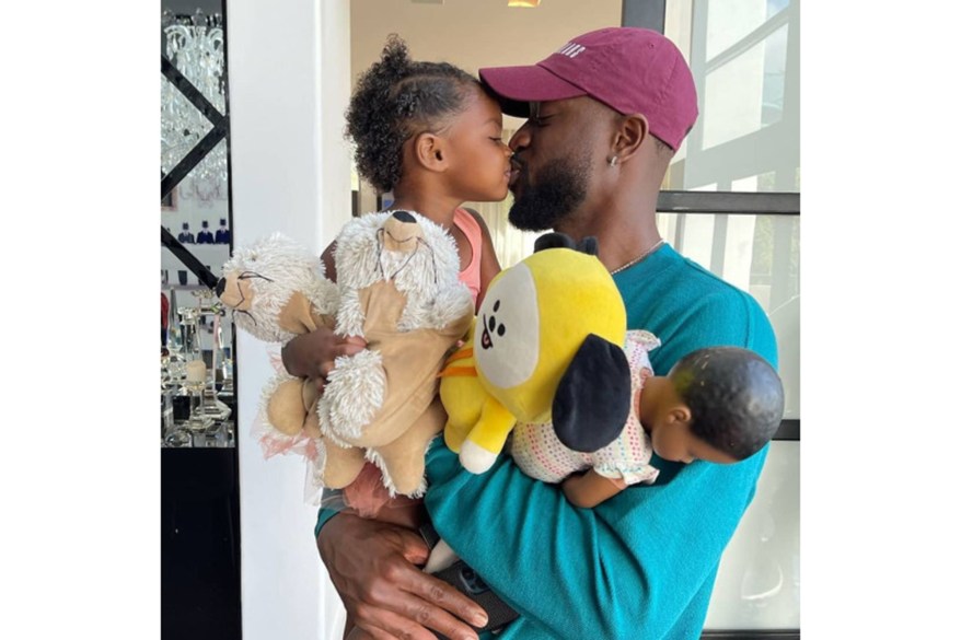 Dwyane Wade kisses his daughter Kaavia -- and her many toys.