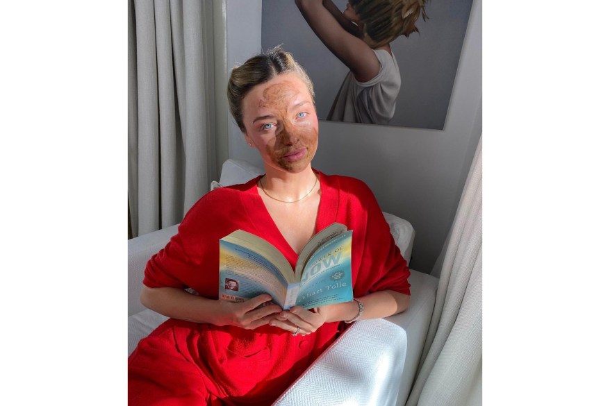 Miranda Kerr dons a face mask while reading “The Power of Now.”