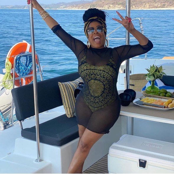 Niecy Nash stuns in a Versace one-piece bathing suit while hanging on a boat.
