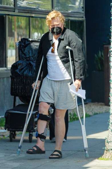 Jesse Plemons hobbles down the street on crutches while wearing a leg brace in LA. (It's not yet known how he was injured.)