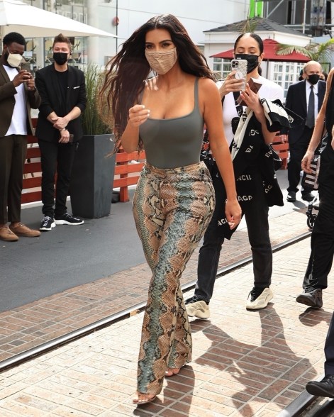 Kim Kardashian rocks snakeskin-print pants at her SKIMS pop-up shop in LA.