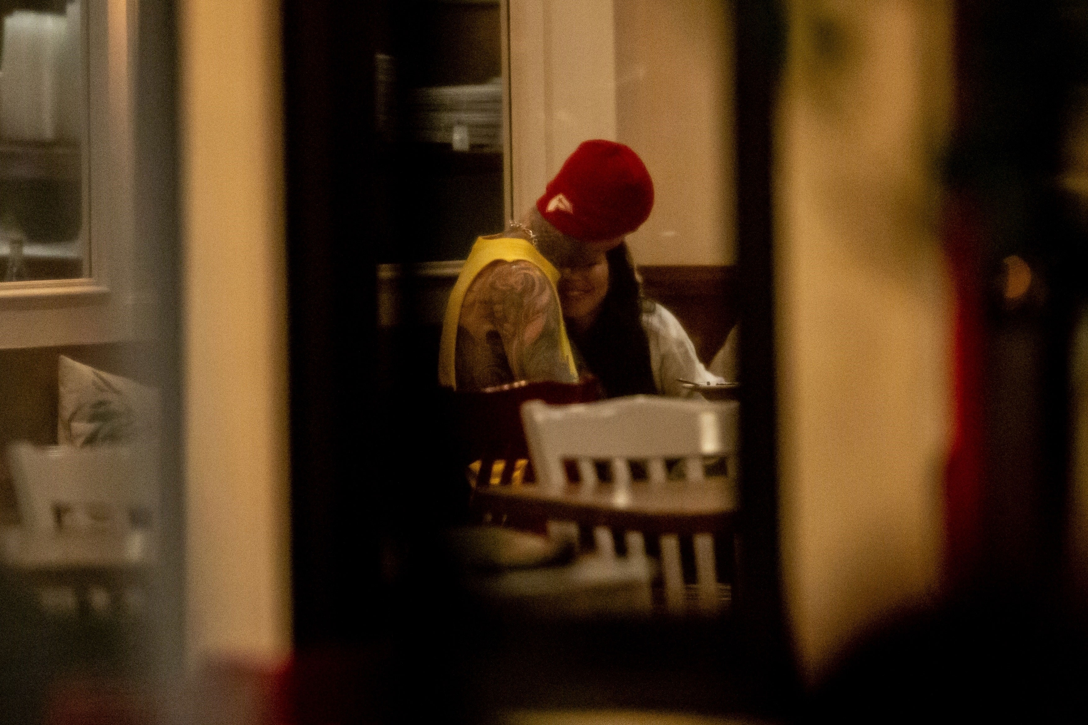 Travis kisses Kourtney on the forehead during dinner.