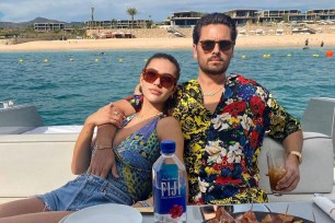 Amelia Gray Hamlin and Scott Disick pose for a photo by the water.