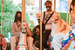 Kourtney Kardashian and Travis Barker on a merry-go-round at Disneyland.