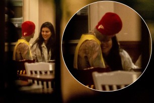 Kourtney Kardashian and Travis Barker kissing.