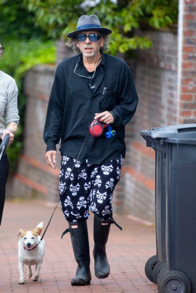 RISE AND SHINE: It’s the nightmare before breakfast. Tim Burton walks his dog through London in scary skull and crossbone pajamas.
