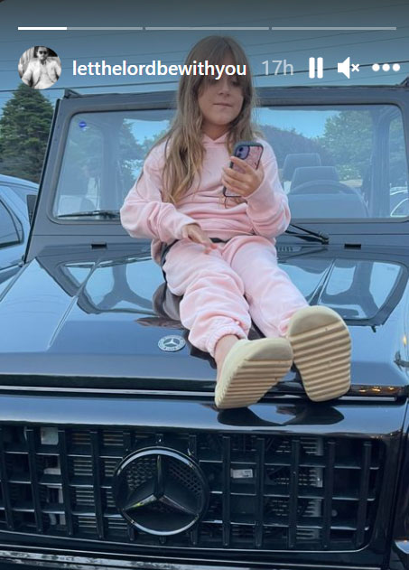 Penelope Disick sitting on a Mercedes SUV