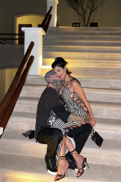 RUB-HER NECKING: Travis Barker palms girlfriend Kourtney Kardashian’s posterior while kissing her on the neck.