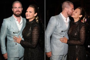 Stephen Amell and Cassandra Jean Amell kiss on a red carpet in Los Angeles.