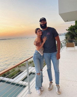 Matt James and Rachael Kirkconnell pose in front of a sunset.