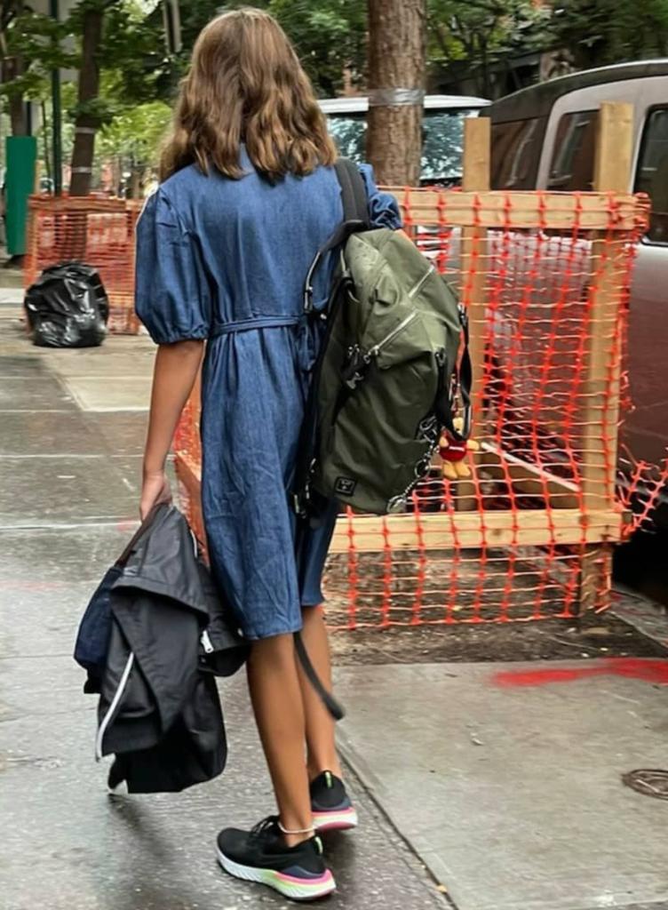 One of Sarah Jessica Parker's twin daughters walks to school with her back facing the camera.