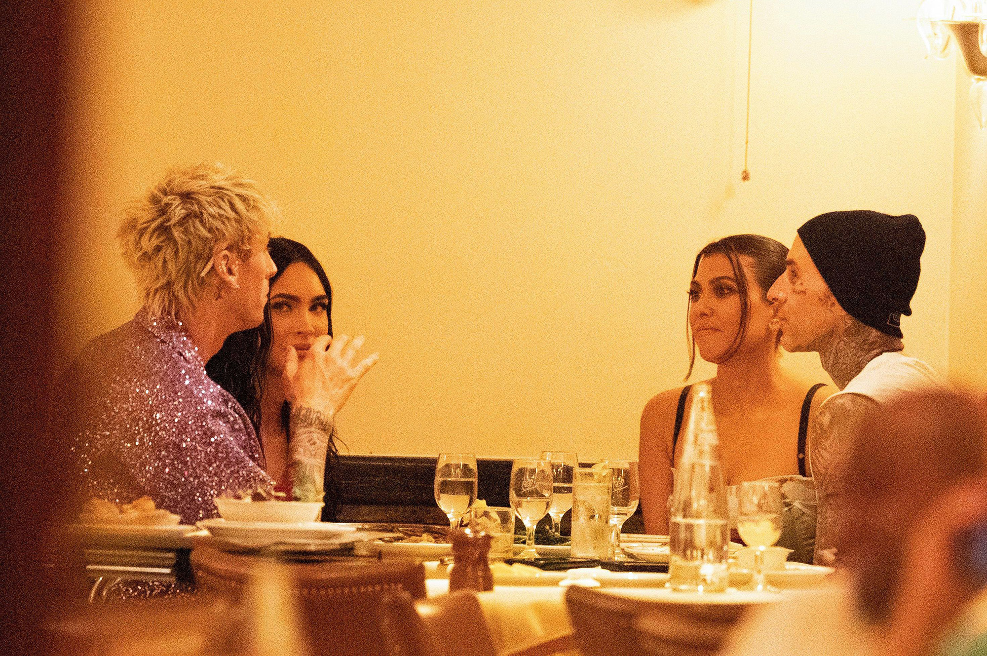 Machine Gun Kelly, Megan Fox, Kourtney Kardashian and Travis Barker dining together.