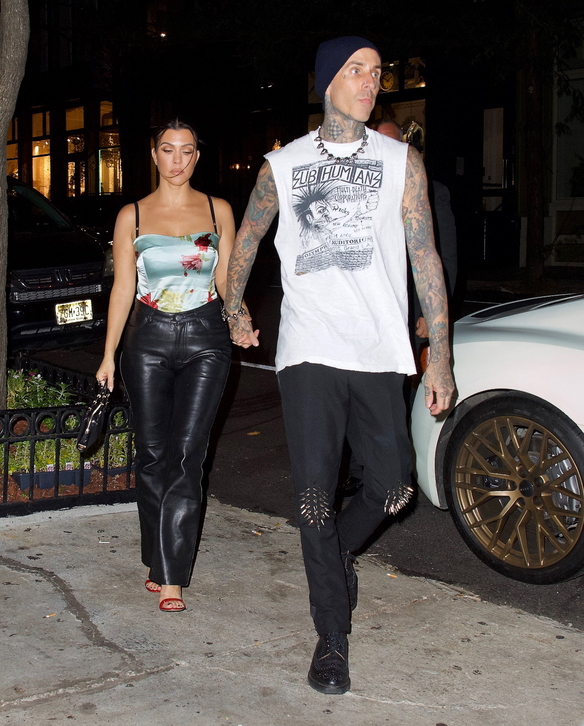 Kourtney Kardashian and Travis Barker holding hands.