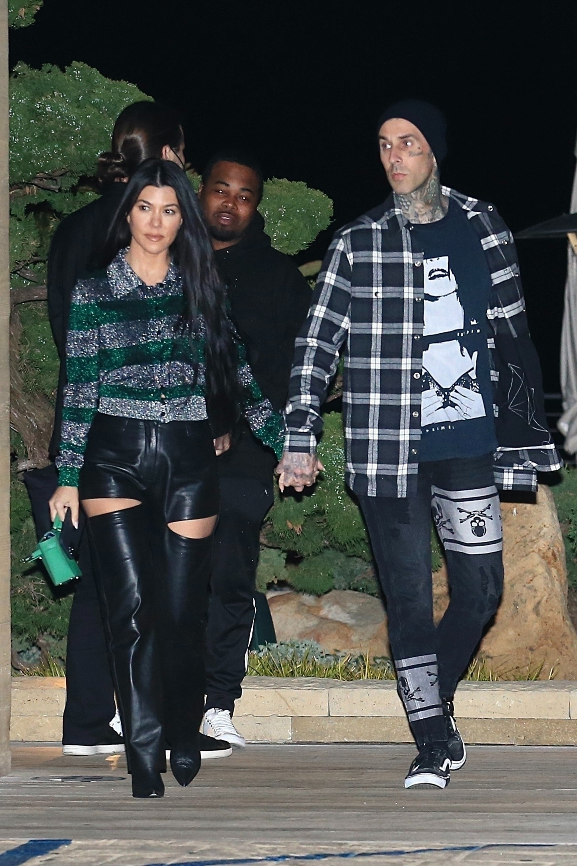 Kourtney Kardashian and Travis Barker walking together.