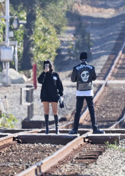 Kourtney Kardashian and Travis Barker on train tracks.