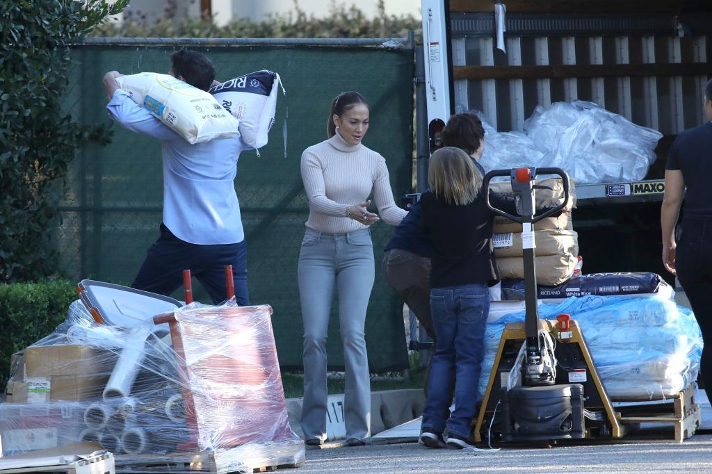 Ben Affleck and Jennifer Lopez hosting a food drive outside of Affleck's home with their children.