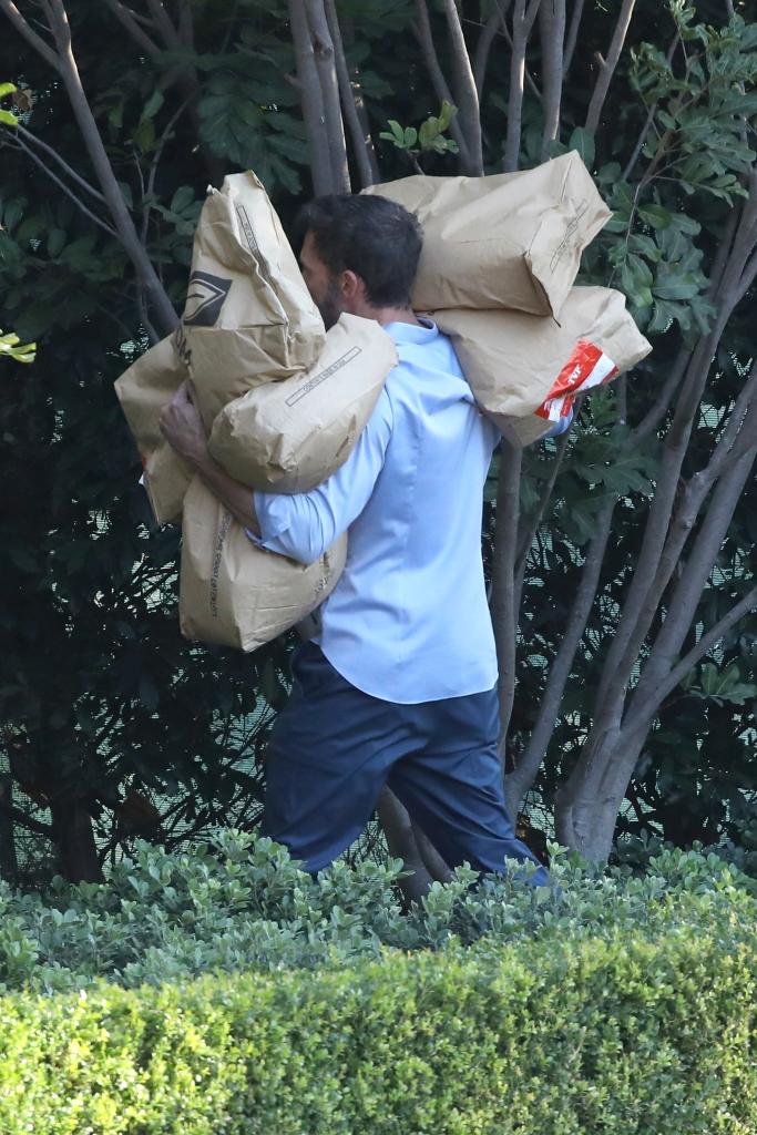 Ben Affleck carrying several bags of rice during a holiday food drive.