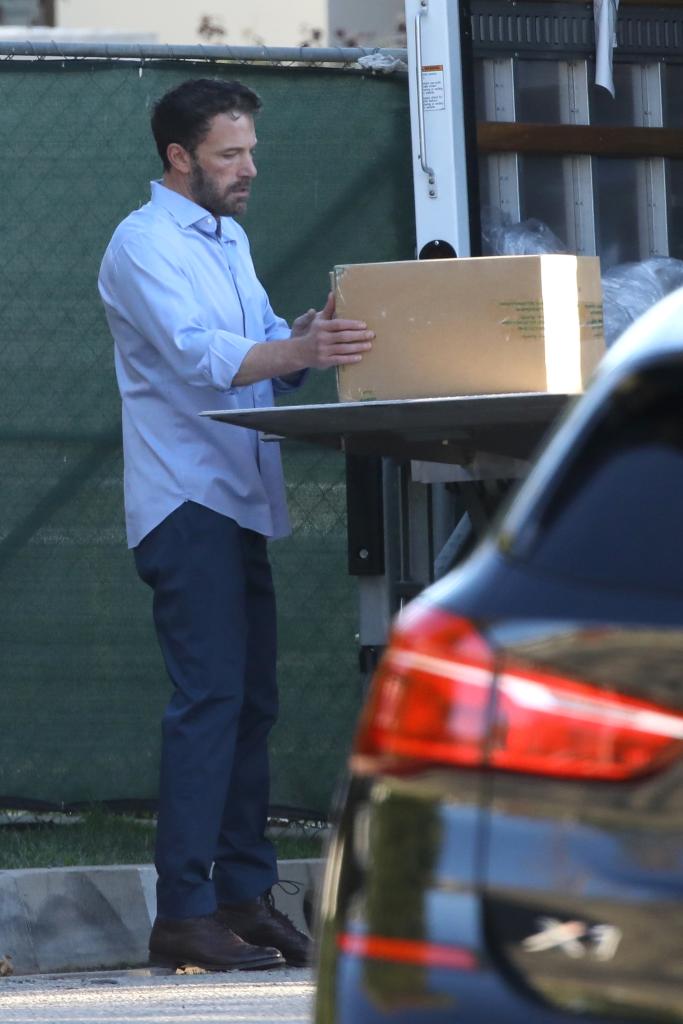 Ben Affleck lifting a box out of a moving truck outside of his home during a holiday food drive.