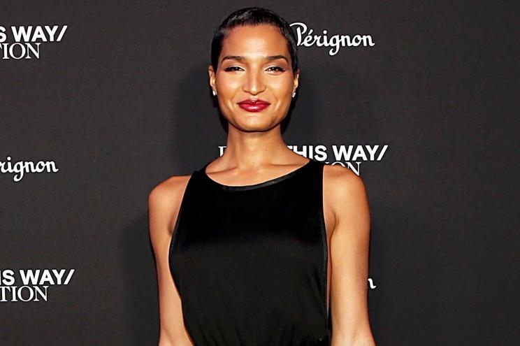 Indya Moore smiles on a red carpet.