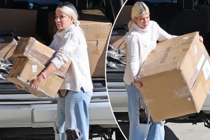 Tori Spelling unloading boxes from a car.