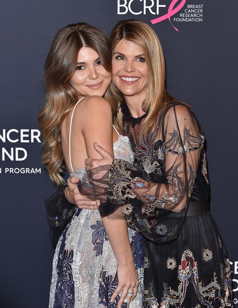 Lori Loughlin and Olivia Jade Giannulli hugging on a red carpet.