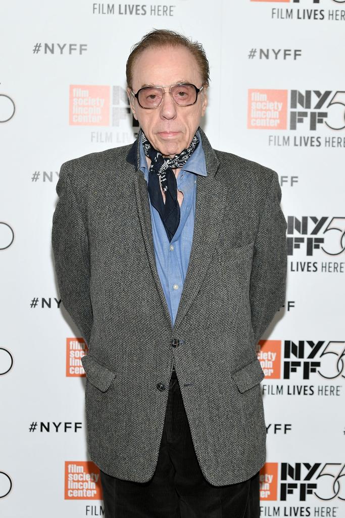 Peter Bogdanovich standing on a red carpet in a suit.