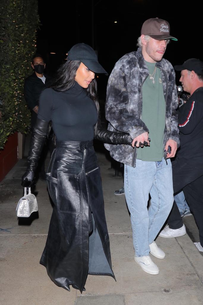 Kim Kardashian and Pete Davidson holding hands.