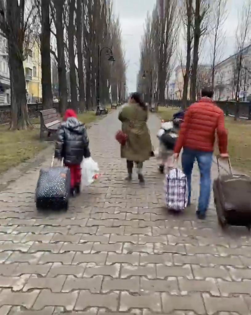 A family fleeing Ukraine with their suitcases in tow.